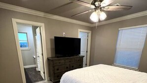 A bedroom with a bed, a ceiling fan, a dresser, and a television. - New Luxury 3 Bed 2 1/2 Bath Duplex (Barling)