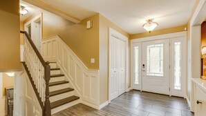 A hallway with a wooden staircase, white doors, and a light fixture on the ceiling. - Amazing Lakeview Retreat with Hot Tub, Sauna and Private Loft! (Tiny)