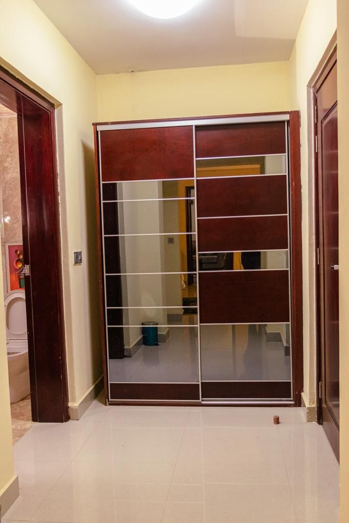 Een kamer met een schuifdeurkast, een toilet en een zichtbare badkamerruimte.