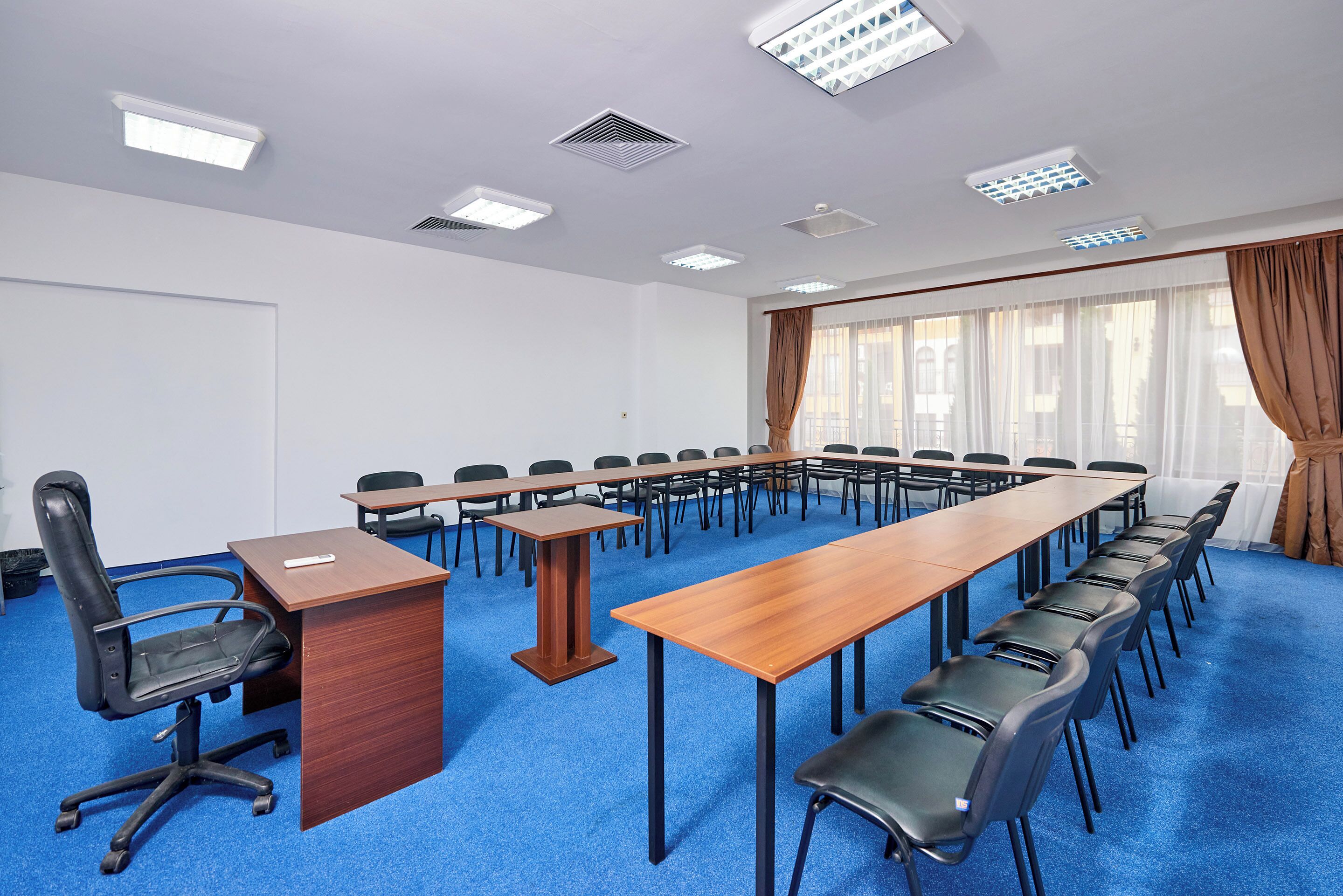 A conference room with a long table, chairs, and a podium.