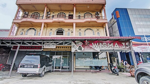 A multi-story building with a ground-level shop named "WISMA 35" and a sign for "NOTARIS & PPAT".