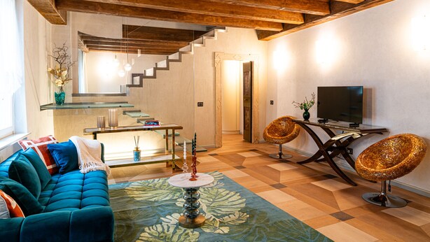 Uma sala de estar moderna com um sofá azul, uma mesa de centro e uma televisão.