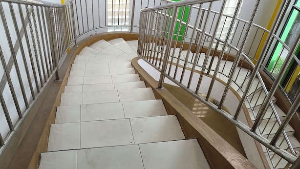 A staircase with metal railings and white tiles.