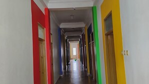 A long, narrow hallway with doors on both sides, leading to rooms.