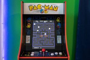 Una máquina arcade de Pac-Man con interfaz de juego de laberinto, indicador de puntaje y botones de control.