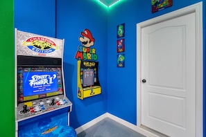 A room with two arcade machines, one for Street Fighter II and another for Super Mario.