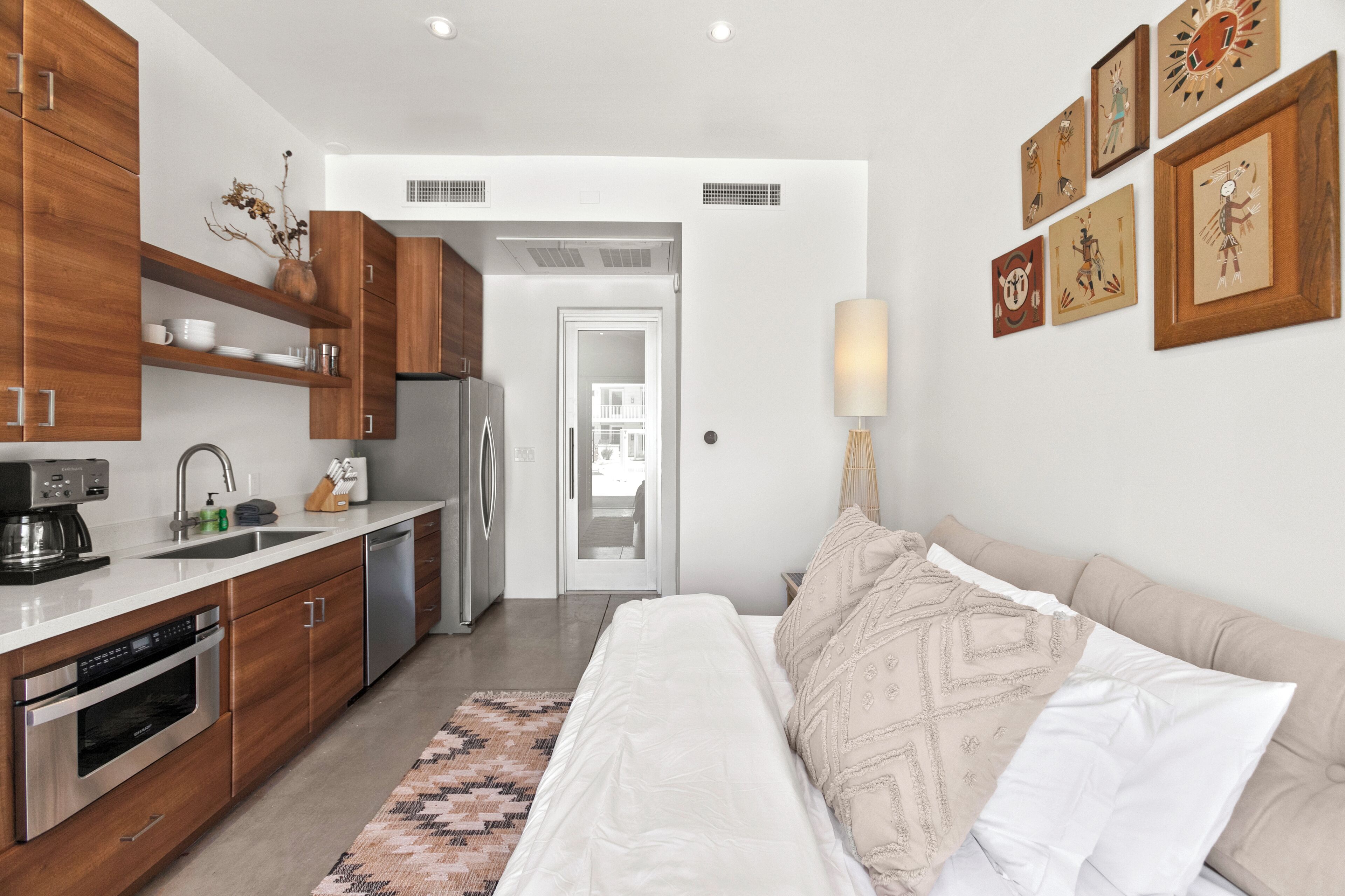 A modern kitchen with wooden cabinets, stainless steel appliances, and a dining area with a table and chairs.