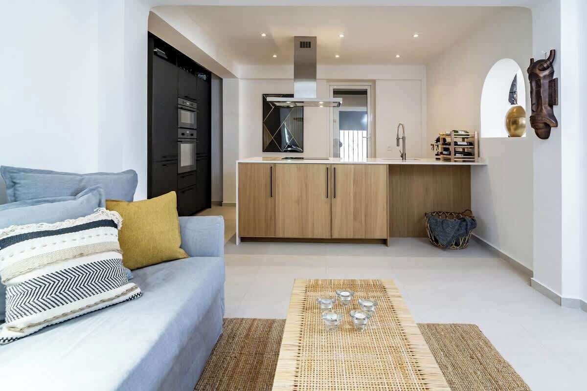 A modern apartment with a living room, kitchenette, and a dining area.