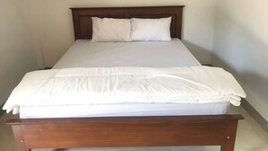 A single bed with a wooden frame and white bedding.