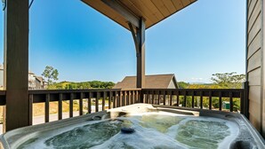 Una vasca idromassaggio su un balcone con vista panoramica sul paesaggio circostante.
