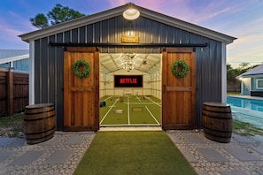 Um edifício rústico em estilo de celeiro, com uma placa na porta que diz 'Cedar Hall' e 'Netflix'.