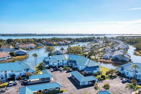 A coastal residential area with houses featuring blue roofs, a marina, and a body of water.