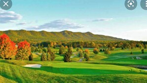 A golf course with a clear path, trees, and a distant mountain range. - Cozy Fall retreat in Massanutten Four Season Mountain Resort ski, bike, fish (McGaheysville)