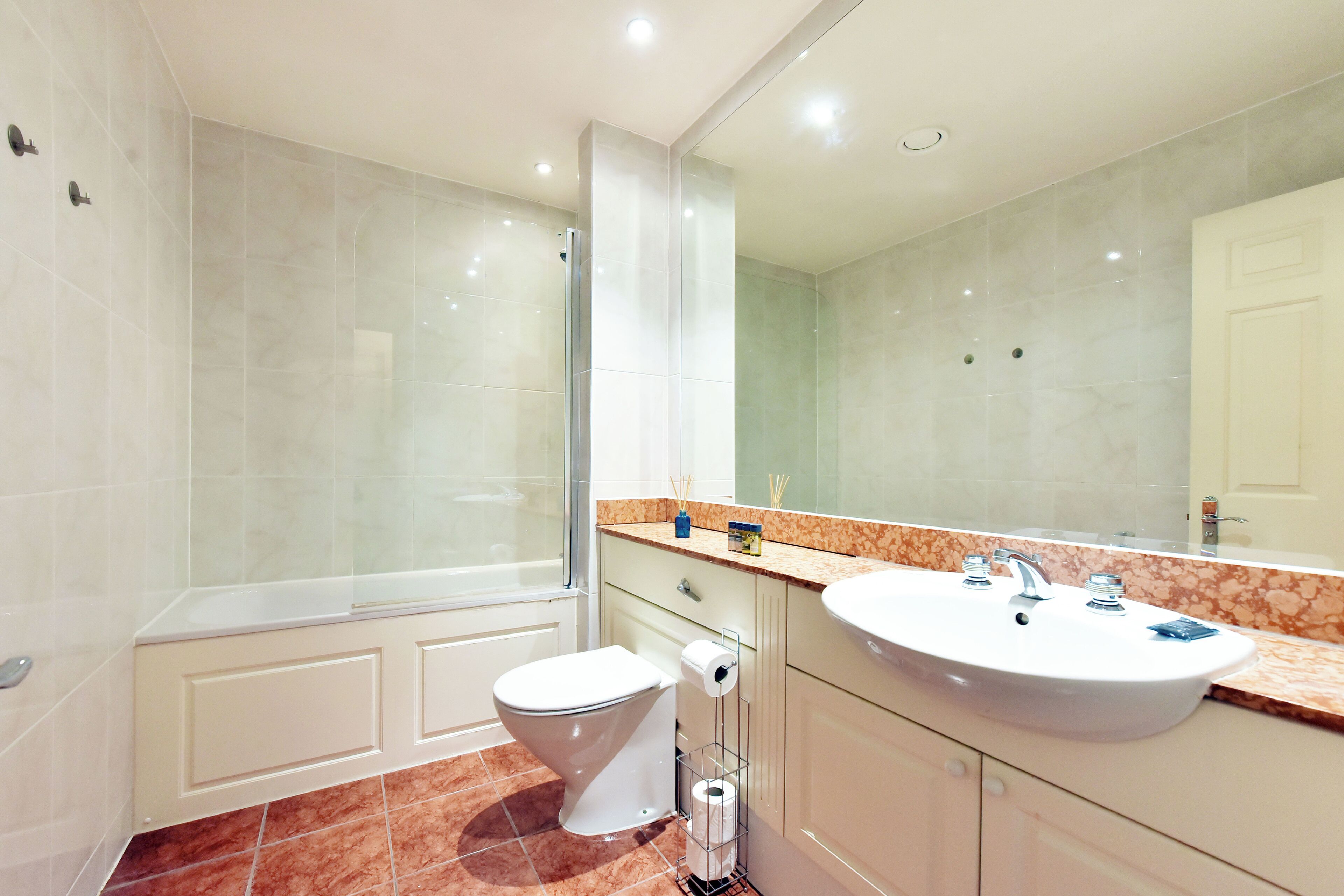 Une salle de bain moderne avec une douche à parois de verre, un lavabo blanc et des toilettes.