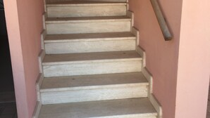 A staircase with a handrail, leading to an upper floor. - TORREGRANDE BEACH ORISTANO (Torre Grande)