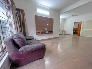 Chambre familiale, vue sur le jardin | Aire de séjour | Téléviseur à écran plat