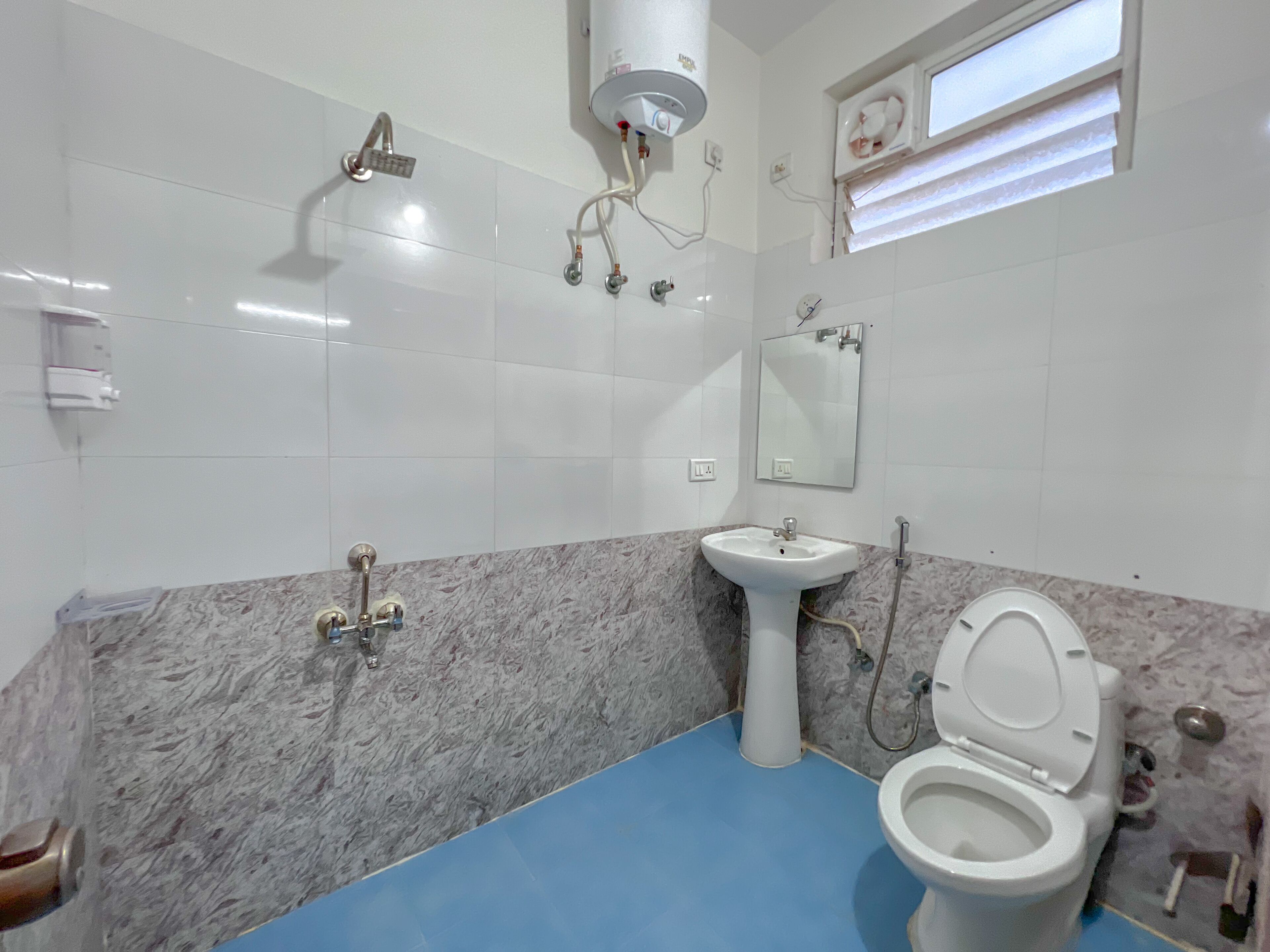 A bathroom with a white sink, a toilet, a shower, and a mirror.