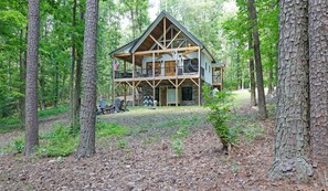 A cabin with a two-story structure, a balcony, and a covered outdoor seating area. - Kerr Lake-Pvt Dock included-Beach area and Cove (Manson)