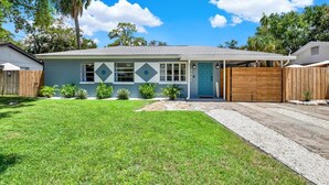 A single-story house with a front garage, a blue door, and a well-maintained lawn.