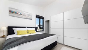 Ein modernes Schlafzimmer mit Bett, Nachttisch und großem Kleiderschrank.
