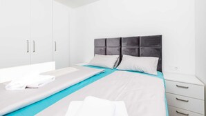 Ein modernes Schlafzimmer mit Bett, Kommode und Kleiderschrank.