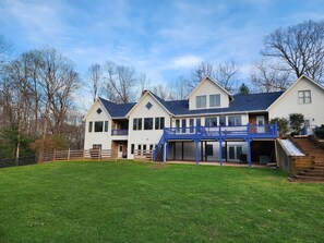 Une maison à deux étages avec un balcon bleu et une véranda.