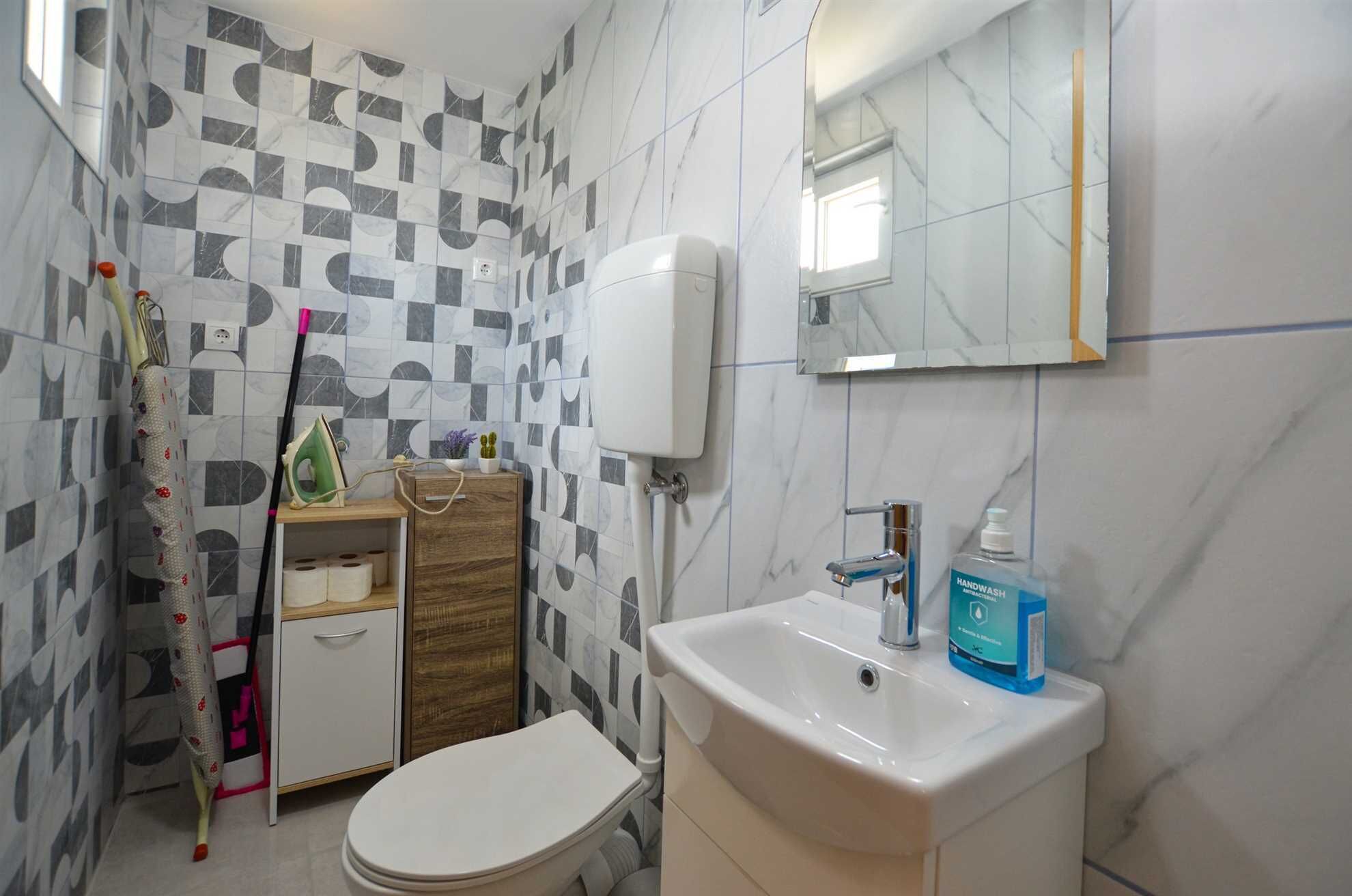 Un bagno con il water, lavandino e zona doccia.
