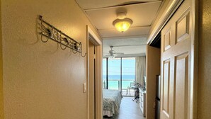 A hallway leading to a bedroom with a view of the ocean.