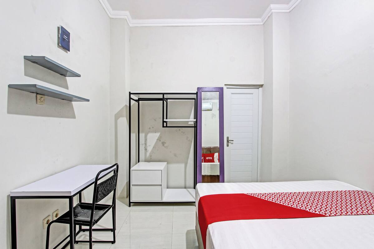 Ein Schlafzimmer mit Bett, Schreibtisch und Kleiderschrank.