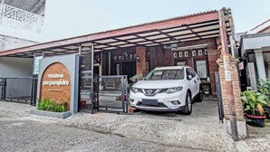 Een witte auto geparkeerd voor een gebouw met een bord waarop 