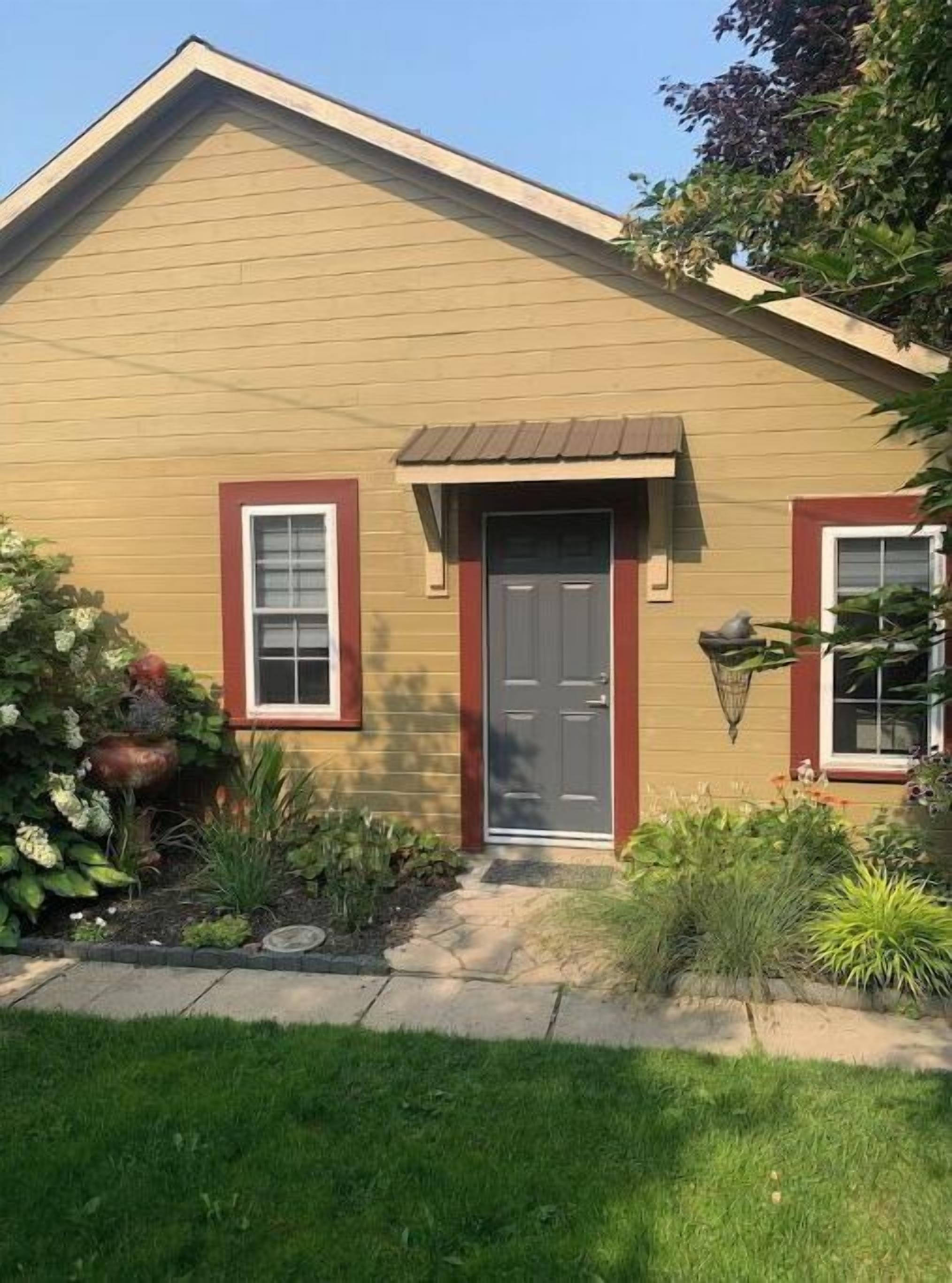 A single-story house with a gabled roof, a front door, and a small porch.