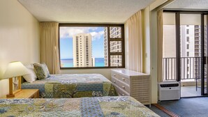 A hotel room with two beds, a dresser, a lamp, and a large window offering a view of a tall building and the ocean. - Honolulu Vacation Rental: Walk to Waikiki Beach! (Honolulu)