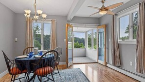 A dining area with a round table, chairs, and a ceiling fan.