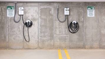 A parking area with two charging stations, each marked with a sign indicating 'charging station' and 'parking only while charging'.