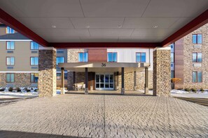 A hotel entrance with a covered walkway, stone pillars, and a number '36' sign. - La Quinta Inn & Suites By Wyndham Williston/Burlington (Williston)