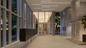 Un espace d’accueil moderne doté d’une cloison en verre, d’un comptoir de réception et offrant une vue sur un bâtiment à travers la vitre.