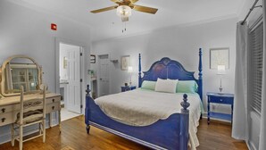 A bedroom with a large bed, a dresser, a ceiling fan, and a window with blinds. - Little Inn on Main 214 West Main Street (Washington)
