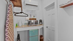 A compact kitchen with a microwave, coffee maker, and a small refrigerator.