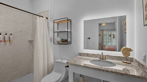 A modern bathroom with a shower, toilet, and sink.