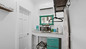 A compact kitchen with a microwave, a small refrigerator, and a sink.
