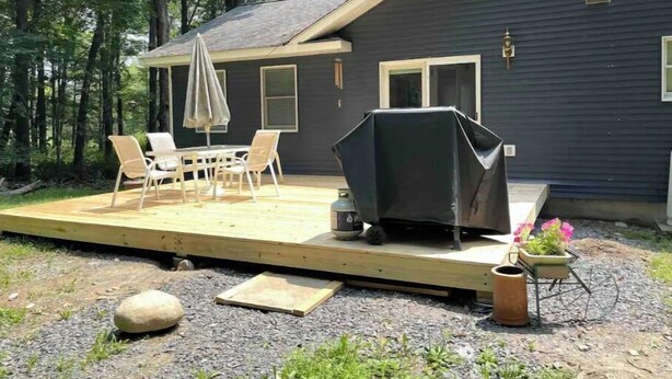 A deck with outdoor furniture, a grill, and a potted plant. - Become at peace in a comfortable country home (New Paltz)