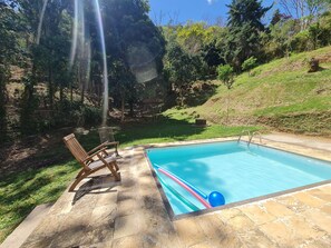 Een buitenzwembad en ligstoelen