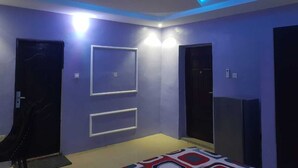 A room with a modern ceiling design, recessed lighting, and a bed with a patterned bedspread. - Enjoy this unique, lavishly furnished 1-bed apartment with "Open Kitchen Design" (Lagos)