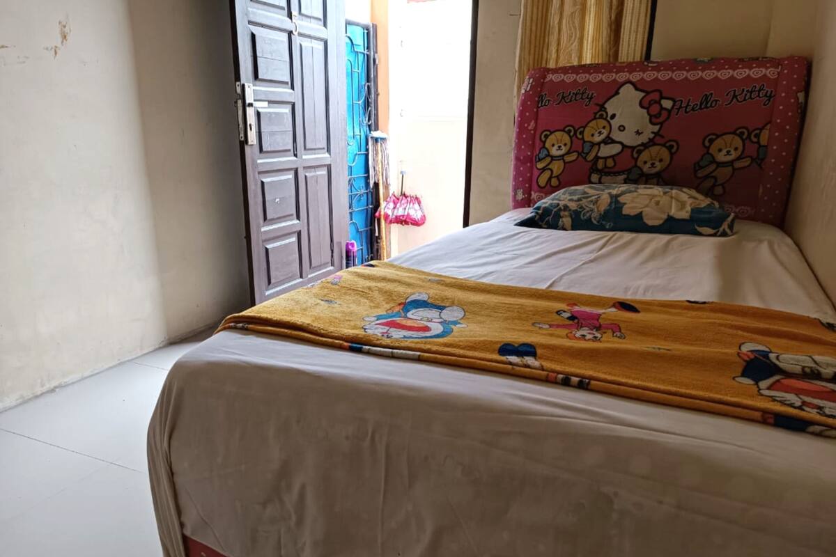 Makuuhuone, jossa on sänky, Hello Kitty -aiheinen tyyny ja Hello Kitty -aiheinen peitto.
