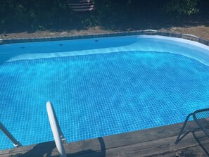 Enjoy a refreshing swim in the pool surrounded by a deck with a ladder for easy access.