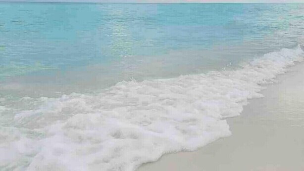 Uma praia com ondas suaves batendo na costa.