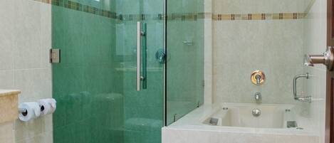 A bathroom with a glass-enclosed shower, a toilet, and a bathtub.