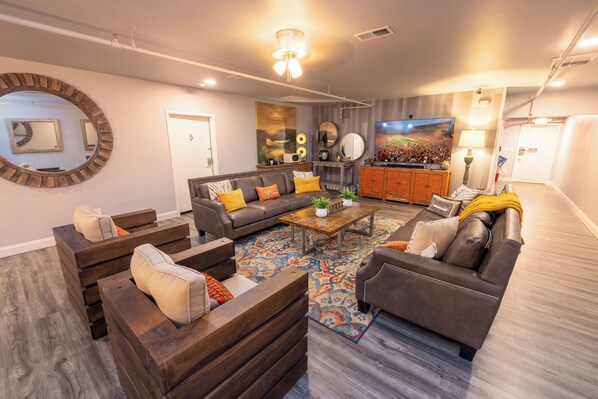 A modern living room with a sectional sofa, a coffee table, and a large TV.