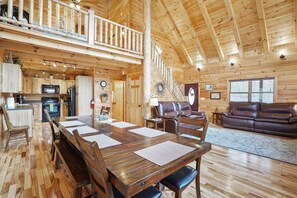 Een ruime houten chalet met een eetruimte, keuken en woonkamer.