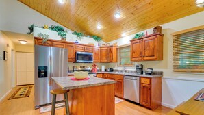 A kitchen with wooden cabinets, stainless steel appliances, and a wooden island. - Quiet Murphy Hideaway w/ Decks & Outdoor Fireplace (Murphy)